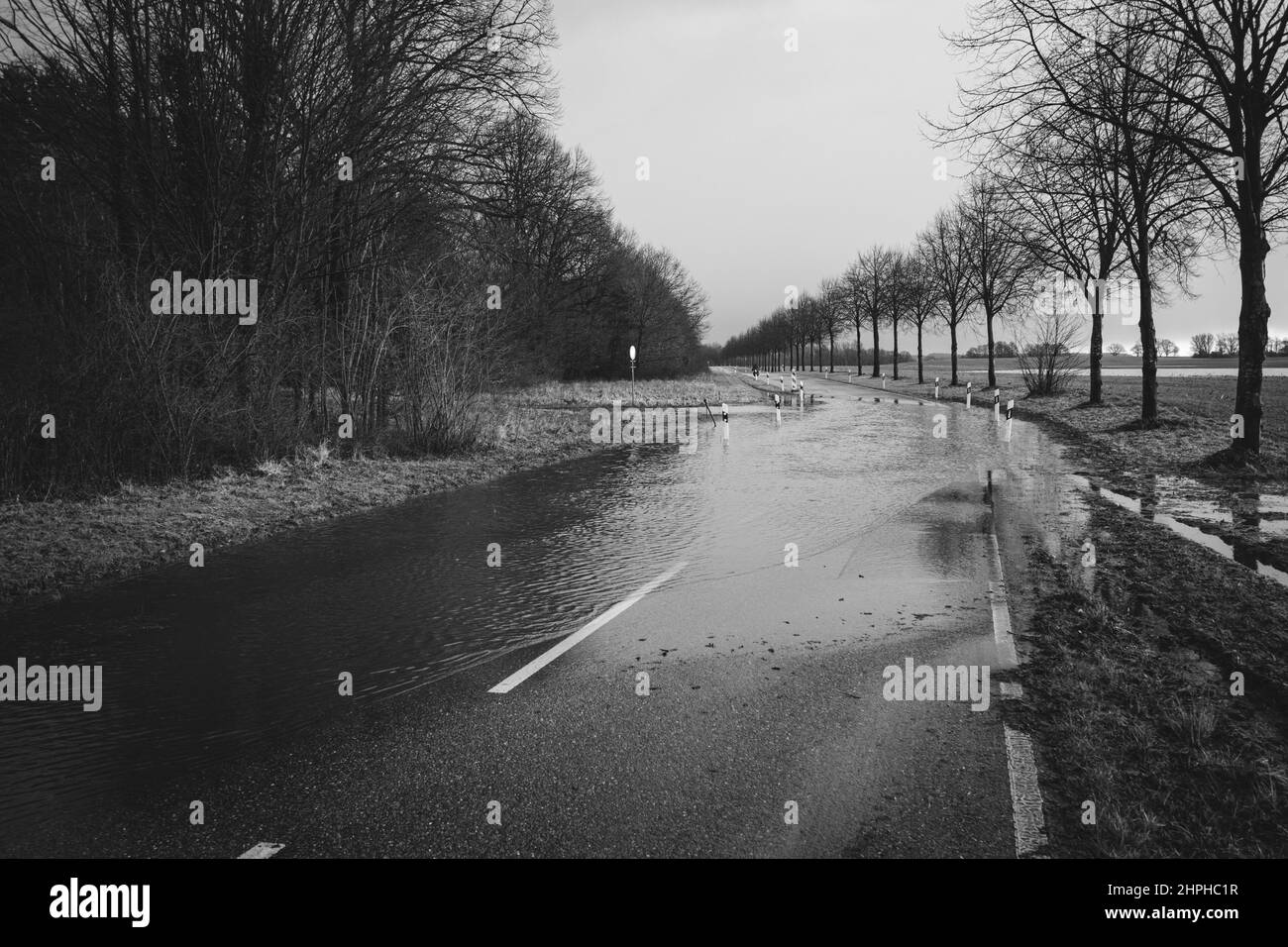 a country road is flooded after heavy rainfall Stock Photo