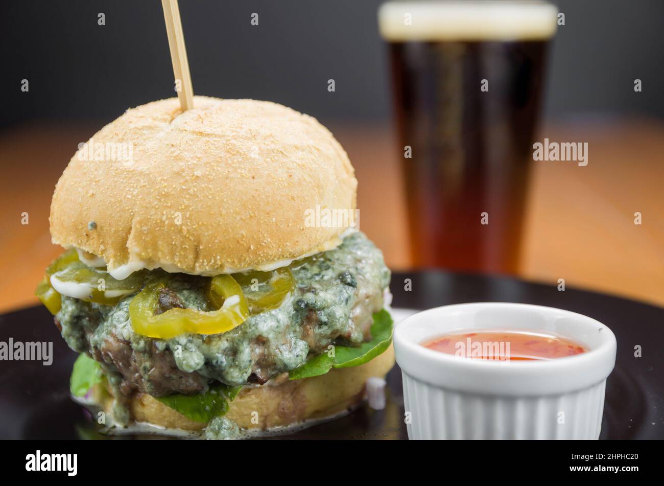 Close-up of tasty homemade hamburger on wooden table and black background Stock Photo