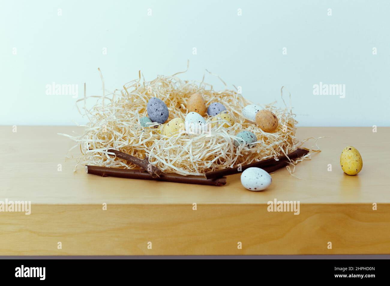 Easter background with blue, white, yellow eggs in nest. Small nest with eggs. Minimal easter composition with easter eggs. empty space, copyspace Stock Photo