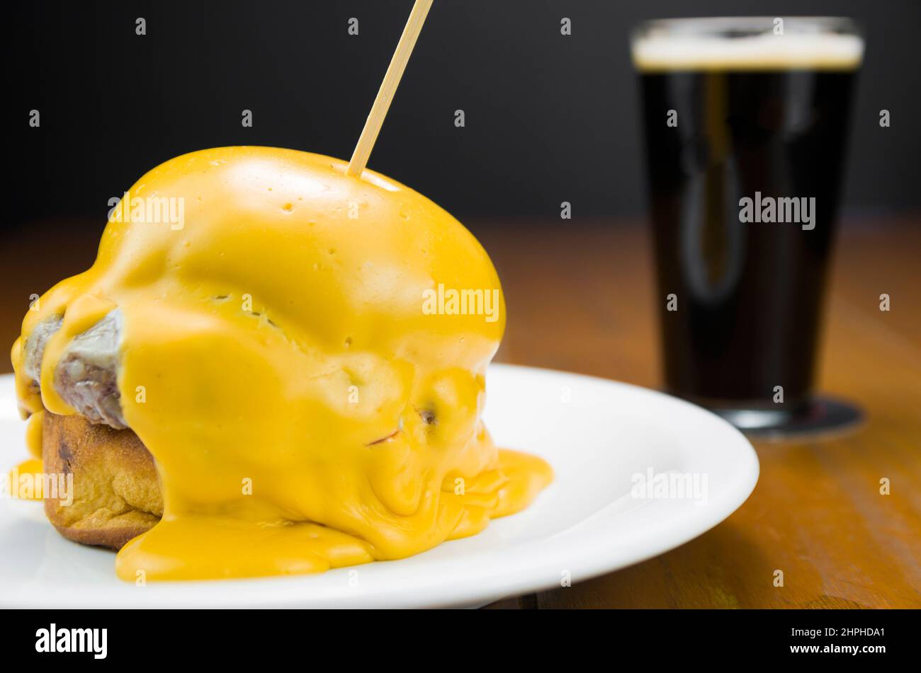 Delicious closeup of hamburger covered in cheddar cheese sauce Stock Photo Alamy