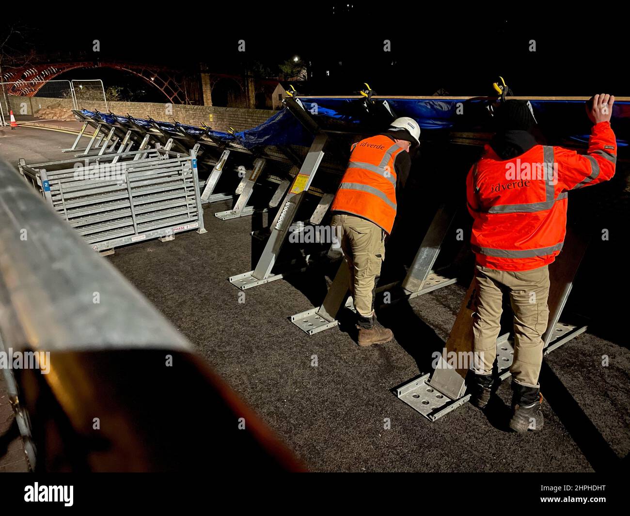 Workmen build flood defences at the River Severn in Ironbridge, Shropshire, following a rare 'severe' warning covering Wharfage, Ironbridge and Wribbenhall, Bewdley, where rising water levels pose a 'significant risk to life', with some residents asked to consider evacuating their homes. Storm Franklin has moved across the UK, just days after Storm Eunice destroyed buildings and left 1.4 million homes without power. Picture date: Monday February 21, 2022. Stock Photo