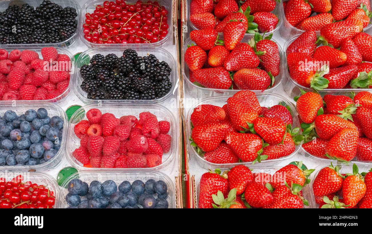 Fresh strawberries, blueberries, currants and raspberries. Fruits prepared for sale. Stock Photo