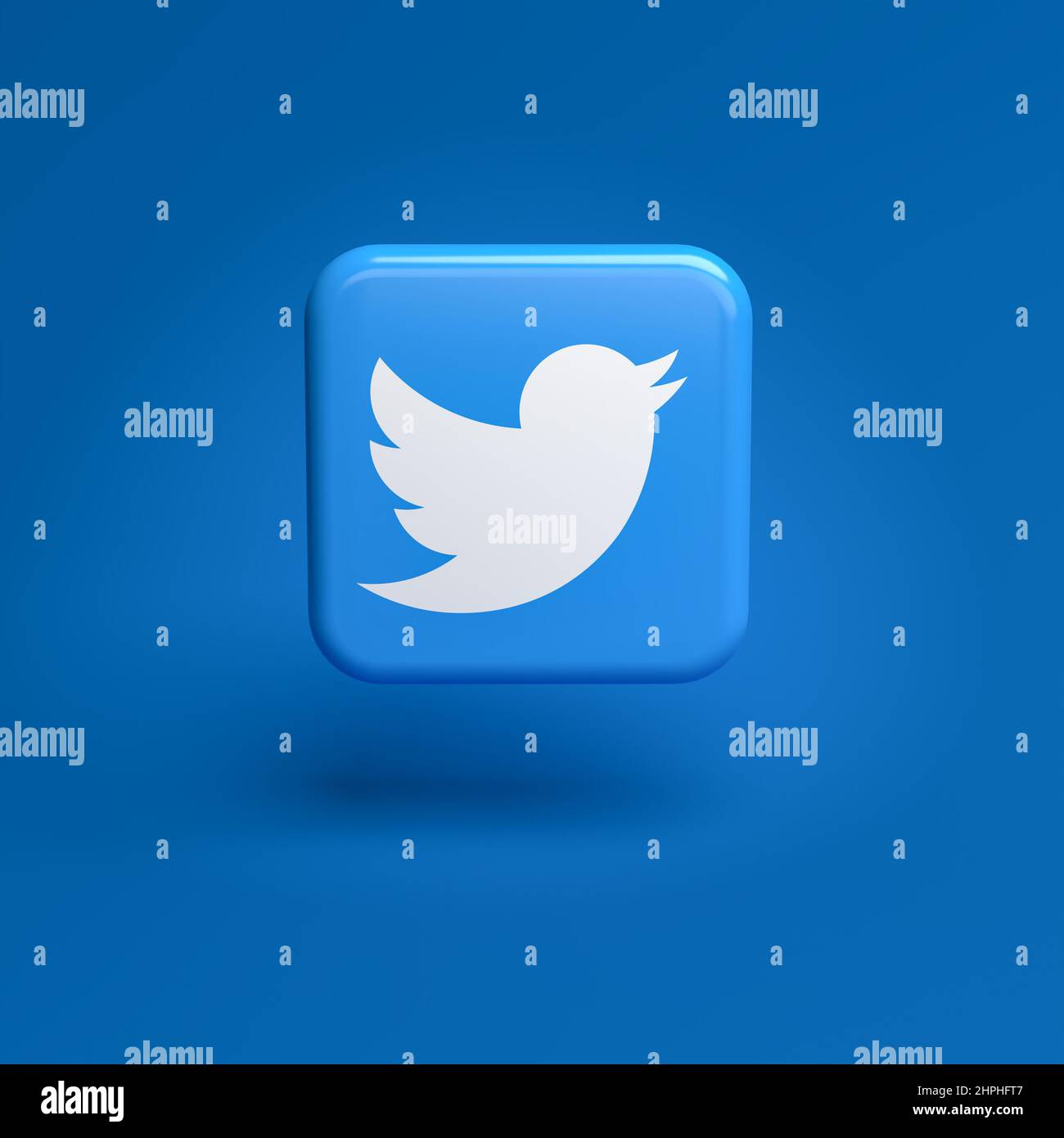 Logo of the social media messaging site and app Twitter on a tile hovering over a seamless blue background Stock Photo