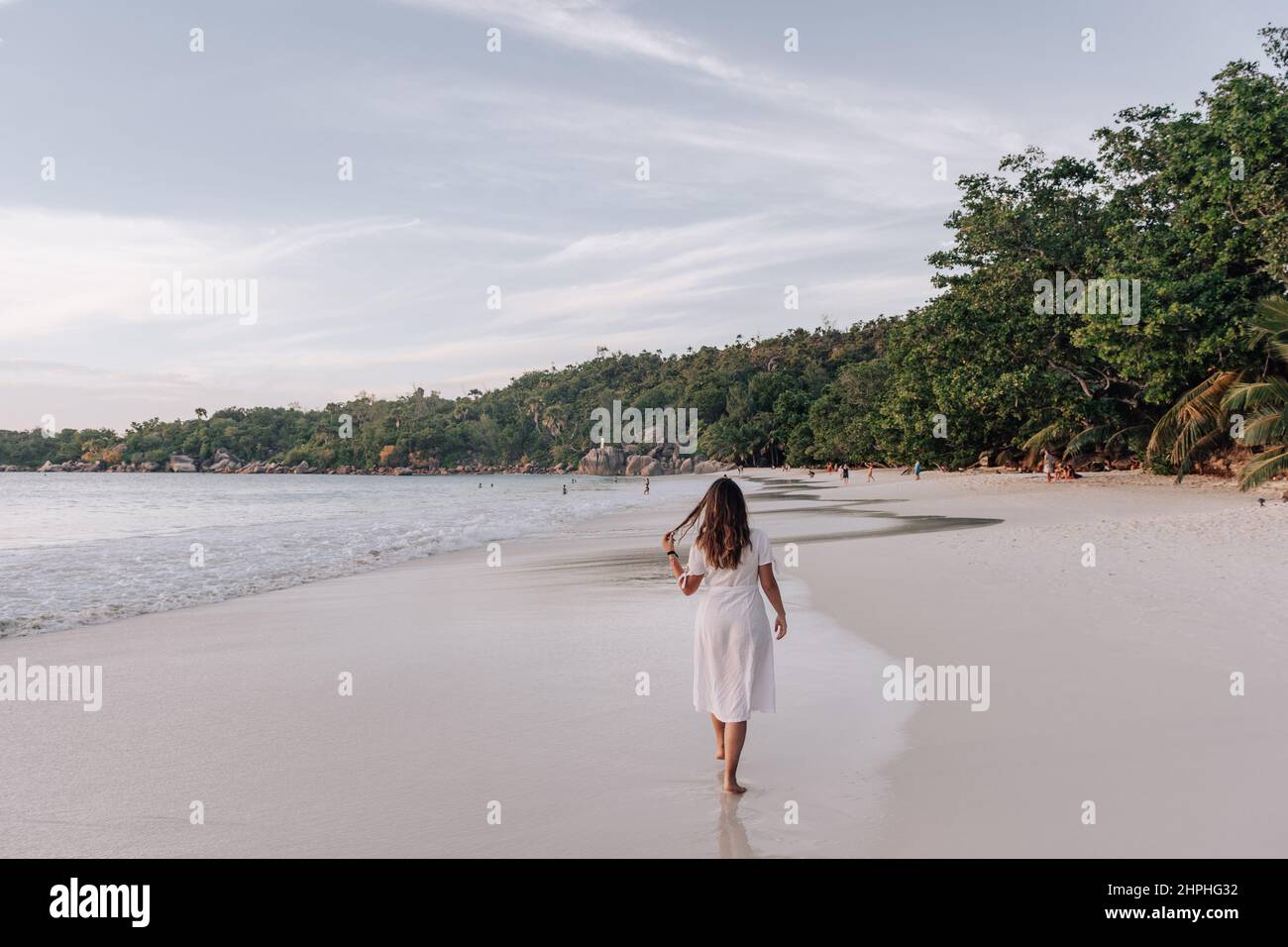 Rear view of Woman in white dress walking on Tropical sandy beach Stock ...