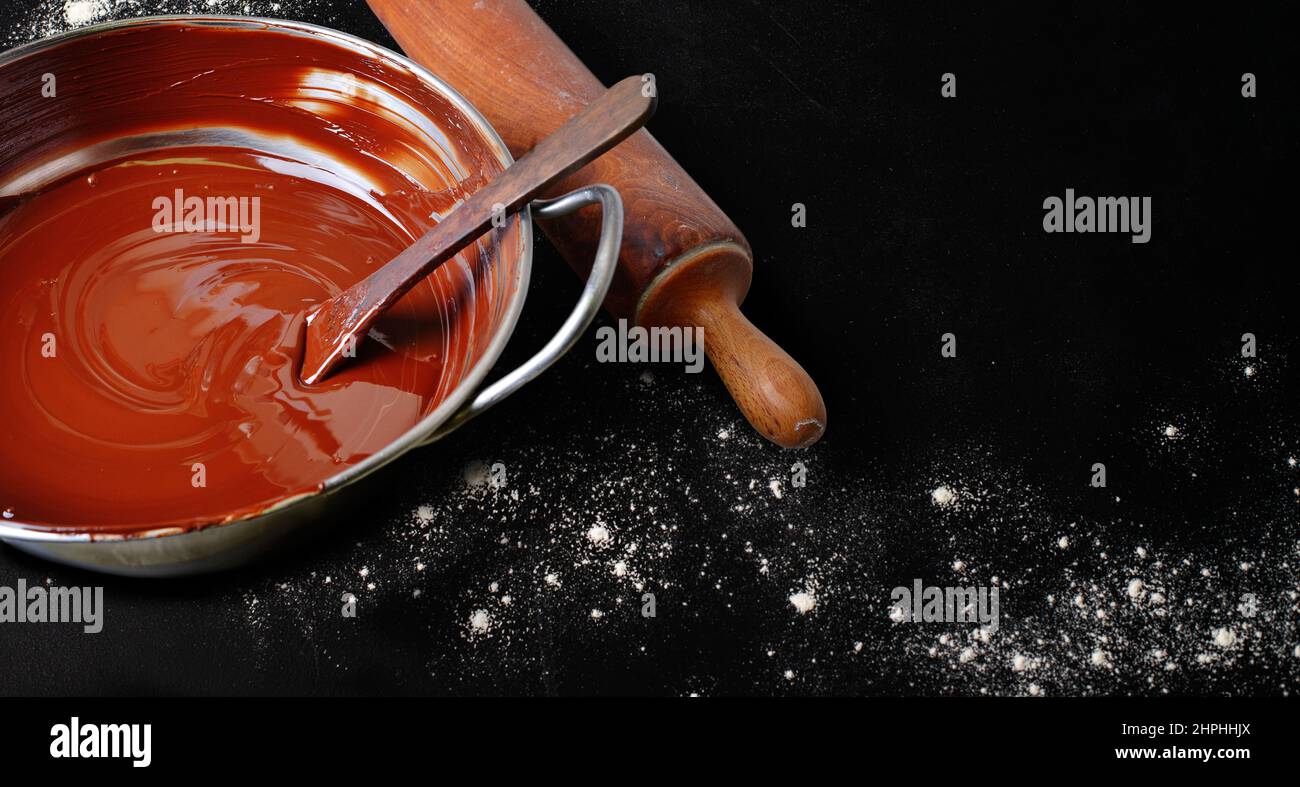 Pastry tools with chocolate residues icing sugar and flour on black