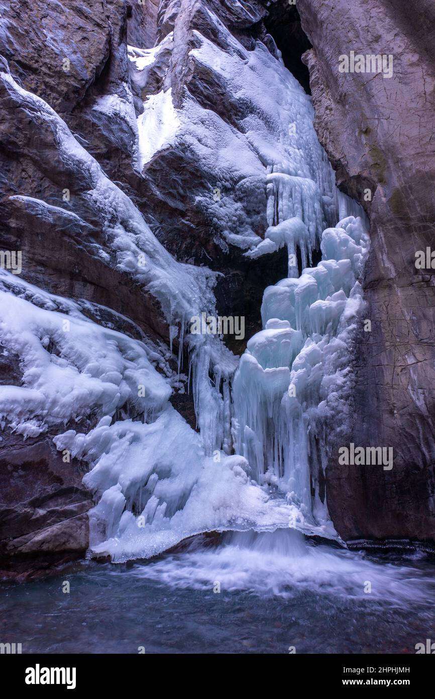 Water cascades out of the bottom of the frozen Box Canyon waterfall in