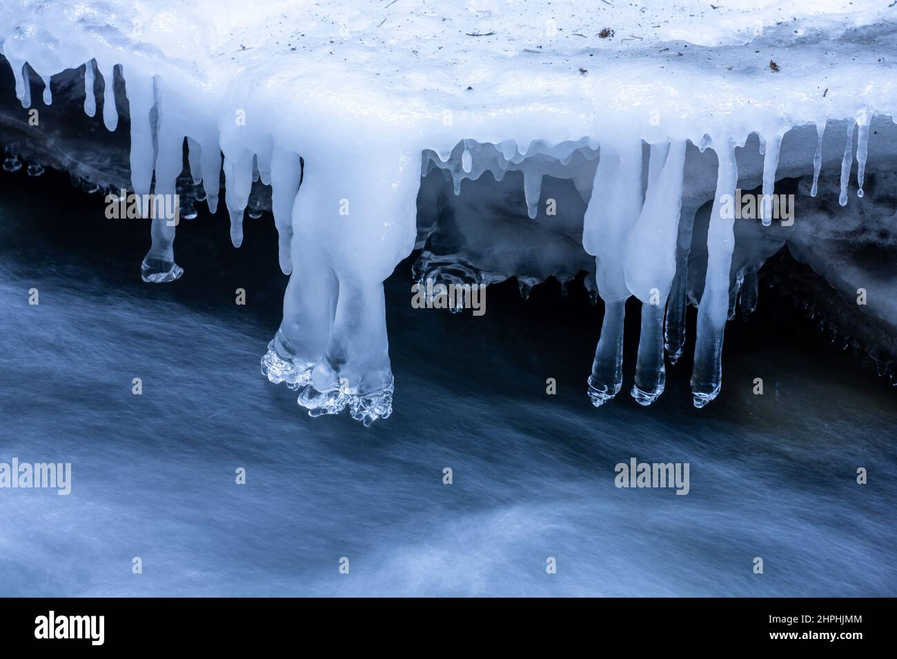 Delicate ice sculptures hang over the moving water of Canyon Creek in