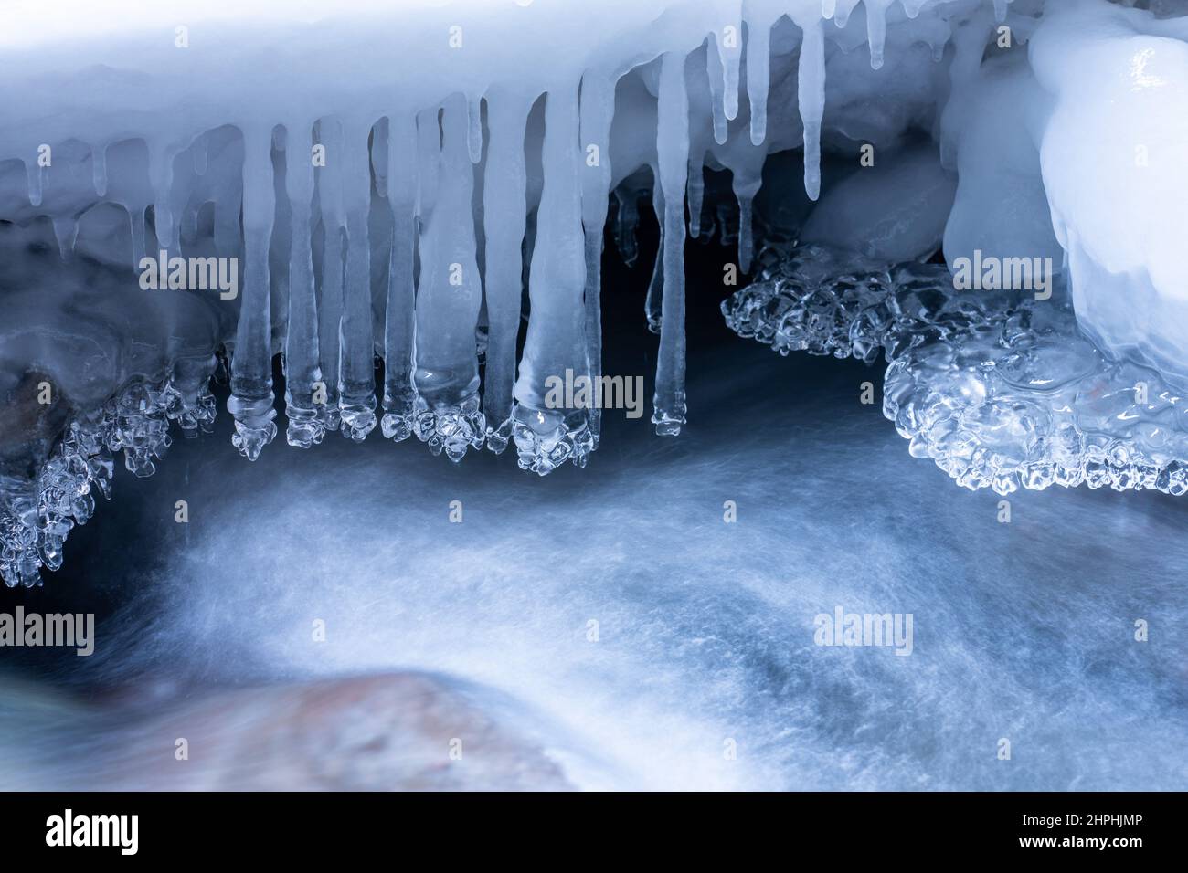 Delicate ice sculptures hang over the moving water of Canyon Creek in