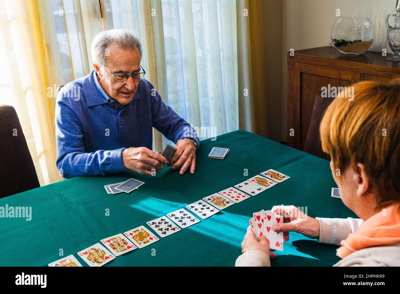 Grandparent's playing a card game in home Stock Photo