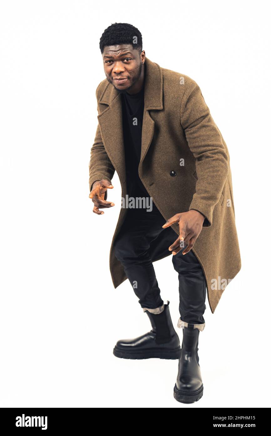 African American male model facing forwards pointing fingers white background - full shot. High-quality photo Stock Photo