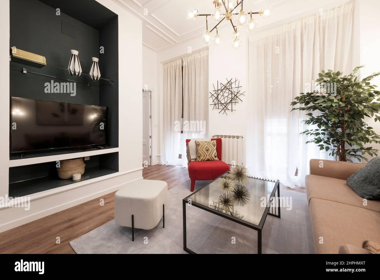 Living room with glass table, cupboard, flat screen TV, sofas and fake