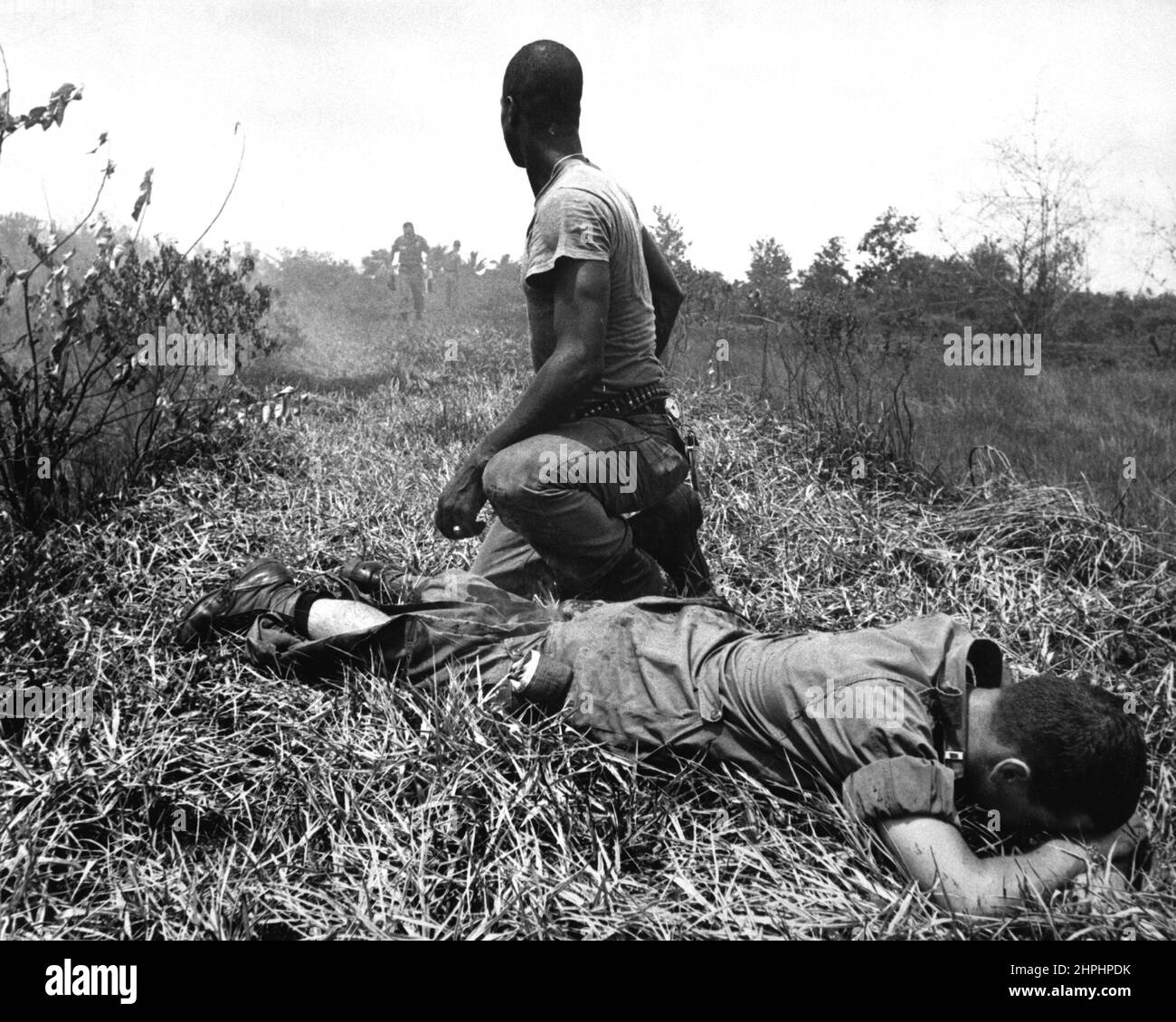 A young American lieutenant, his leg burned by an exploding Viet Cong white phosphorus booby trap, is treated by a medic. ca.  1966 Stock Photo