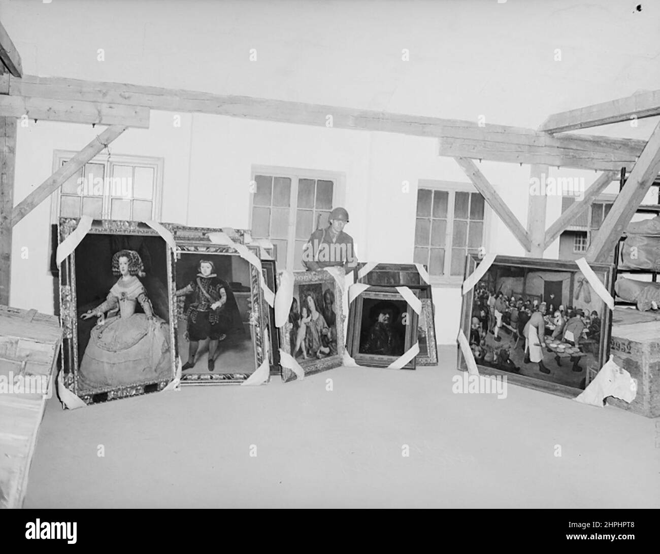 Various paintings in a storeroom at Schloss Klessheim, including Pieter Bruegel's Peasant Wedding. The person behind is a US Forces corporal ca.  23 June 1945 Stock Photo