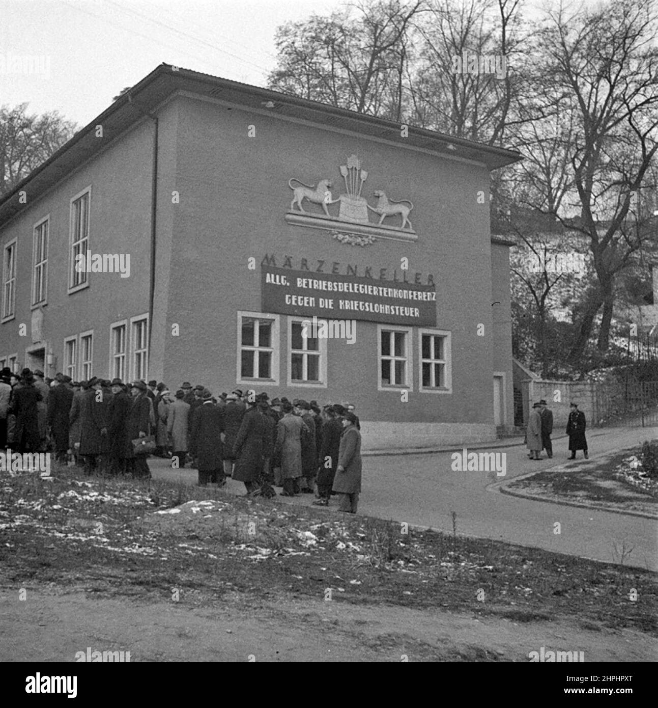 The former Marchenkeller inn in Linz. The people in the foreground are delegates of a works delegate conference of the KPÖ. The inscription on the banner reads: General conference of works delegates against the war wage tax ca.  December 1952 Stock Photo