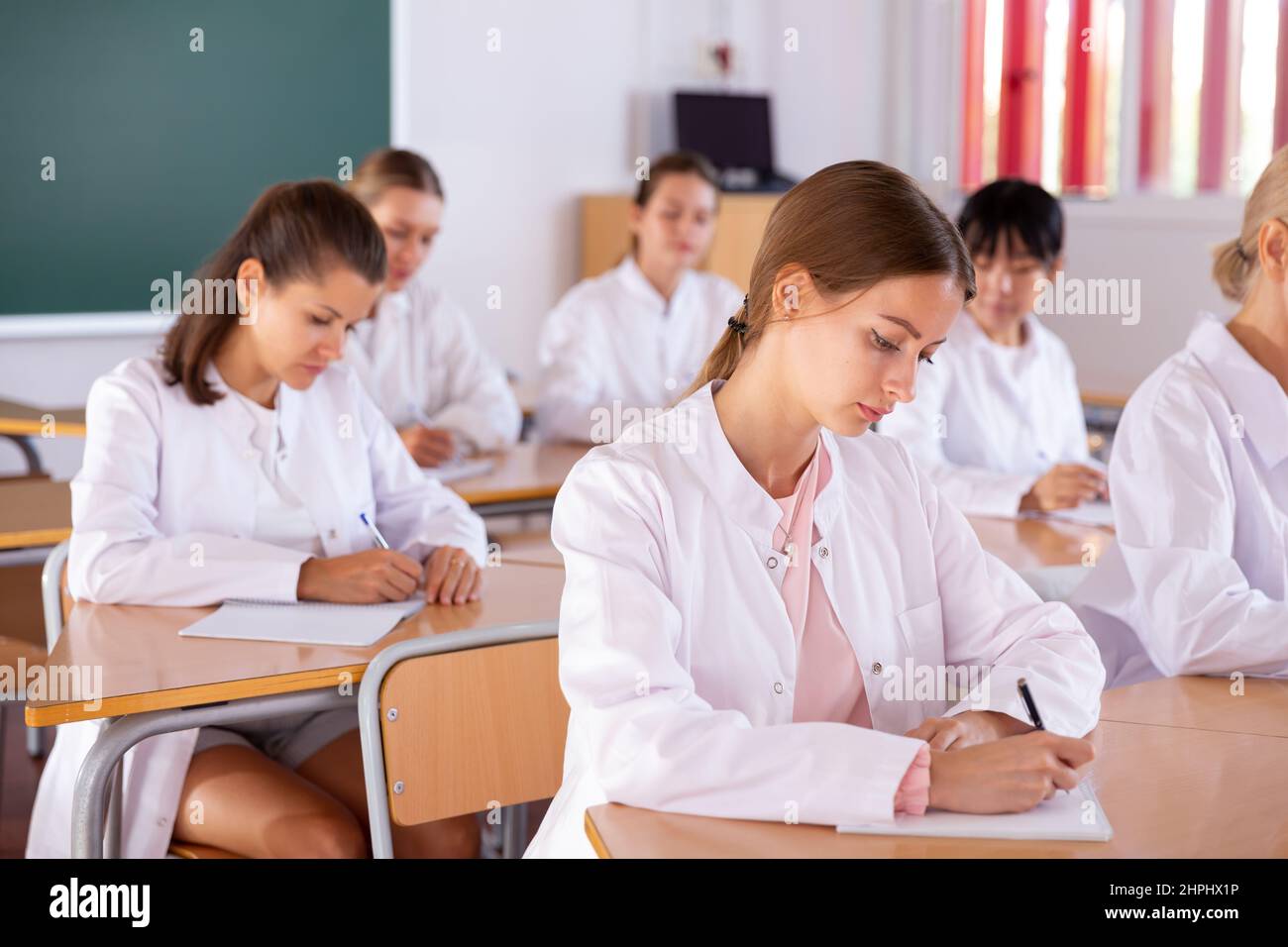 Medical students writing in notepads Stock Photo