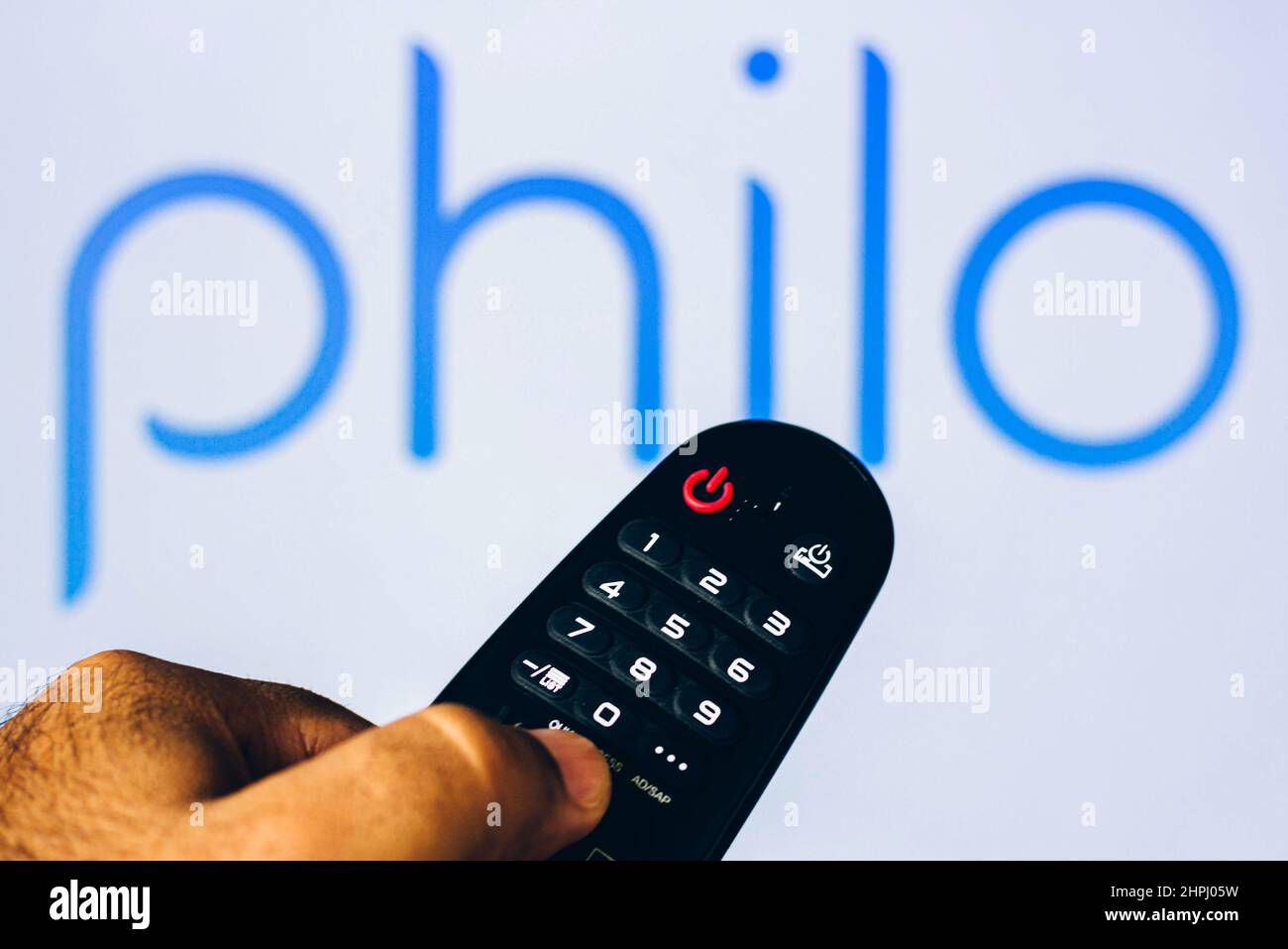 Brazil. 21st Feb, 2022. In this photo illustration a close-up of a hand holding a TV remote control seen displayed in front of the Philo logo. (Photo by Rafael Henrique/SOPA Images/Sipa USA) Credit: Sipa USA/Alamy Live News Stock Photo