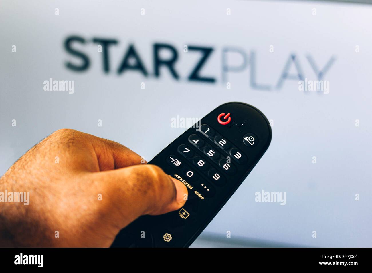 In this photo illustration a close-up of a hand holding a TV remote ...