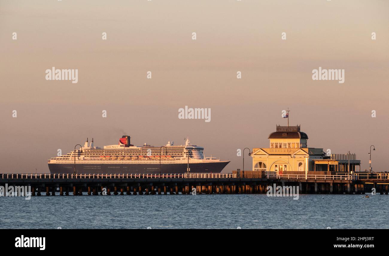 RMS Queen Mary 2 passes the St Kilda Pier on Port Phillip Bay, Melbourne, Australia . Stock Photo