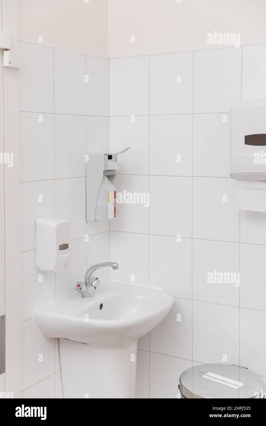 Public toilet cabin. Clean empty hospital washroom with a sanitizer or dispenser or alcohol solution for hand disinfection , close-up. Place for Stock Photo