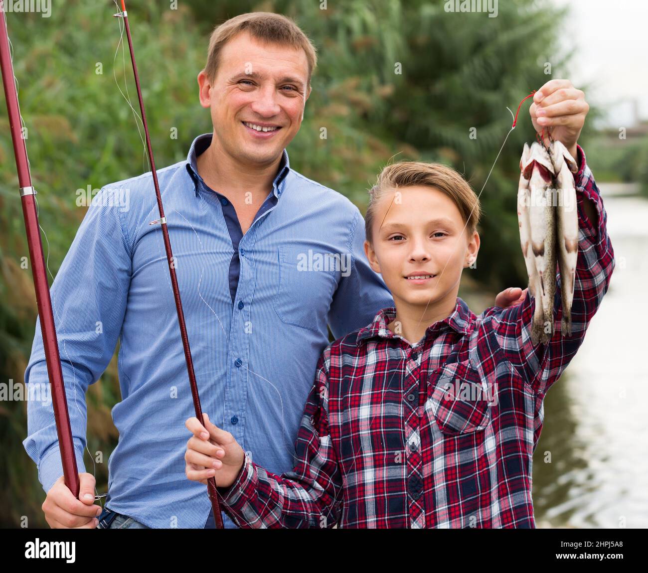 Adult father with son looking at fish on hook Stock Photo