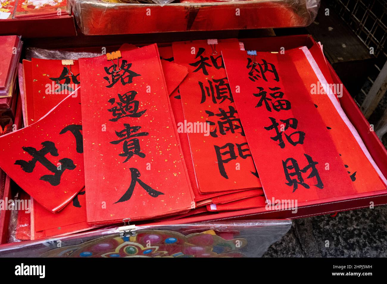 Handwritten traditional Chinese red couplets for Chinese New Year on sale at market Stock Photo