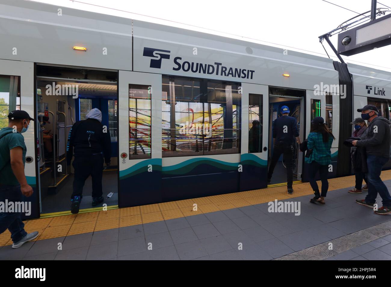 People boarding a Sound Transit 1 line Link light rail train in Seattle, Washington. Stock Photo