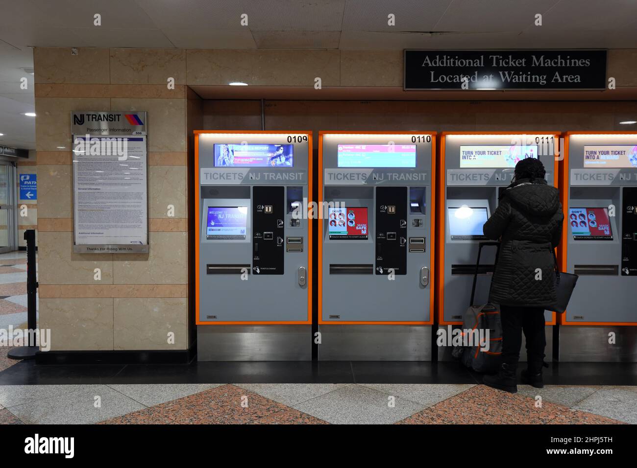 A person uses a NJ Transit automatic ticket machine at Penn Station, New York, NY. Stock Photo