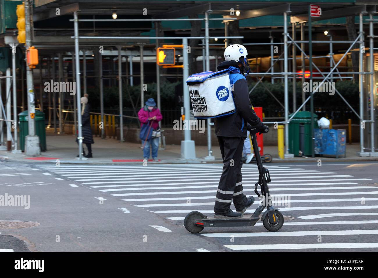 A Fridge No More delivery person on an e scooter making a rapid demand, on demand delivery in New York, Feb 20, 2022. q commerce Stock Photo