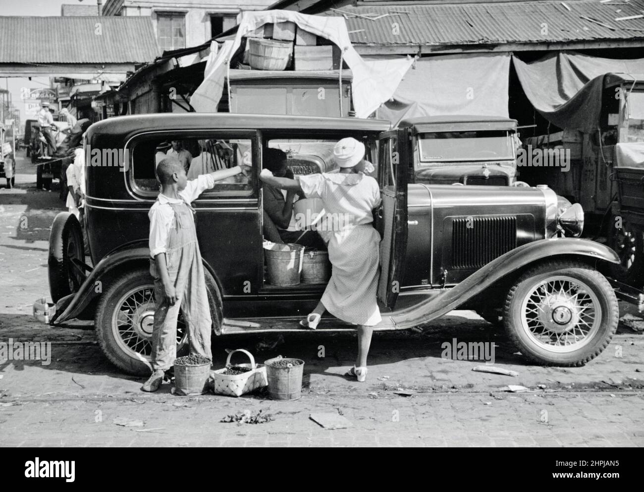 Carl Mydans - Marketplace at New Orleans, Louisiana, Woman boards Chevrolet automobile - 1936 Stock Photo