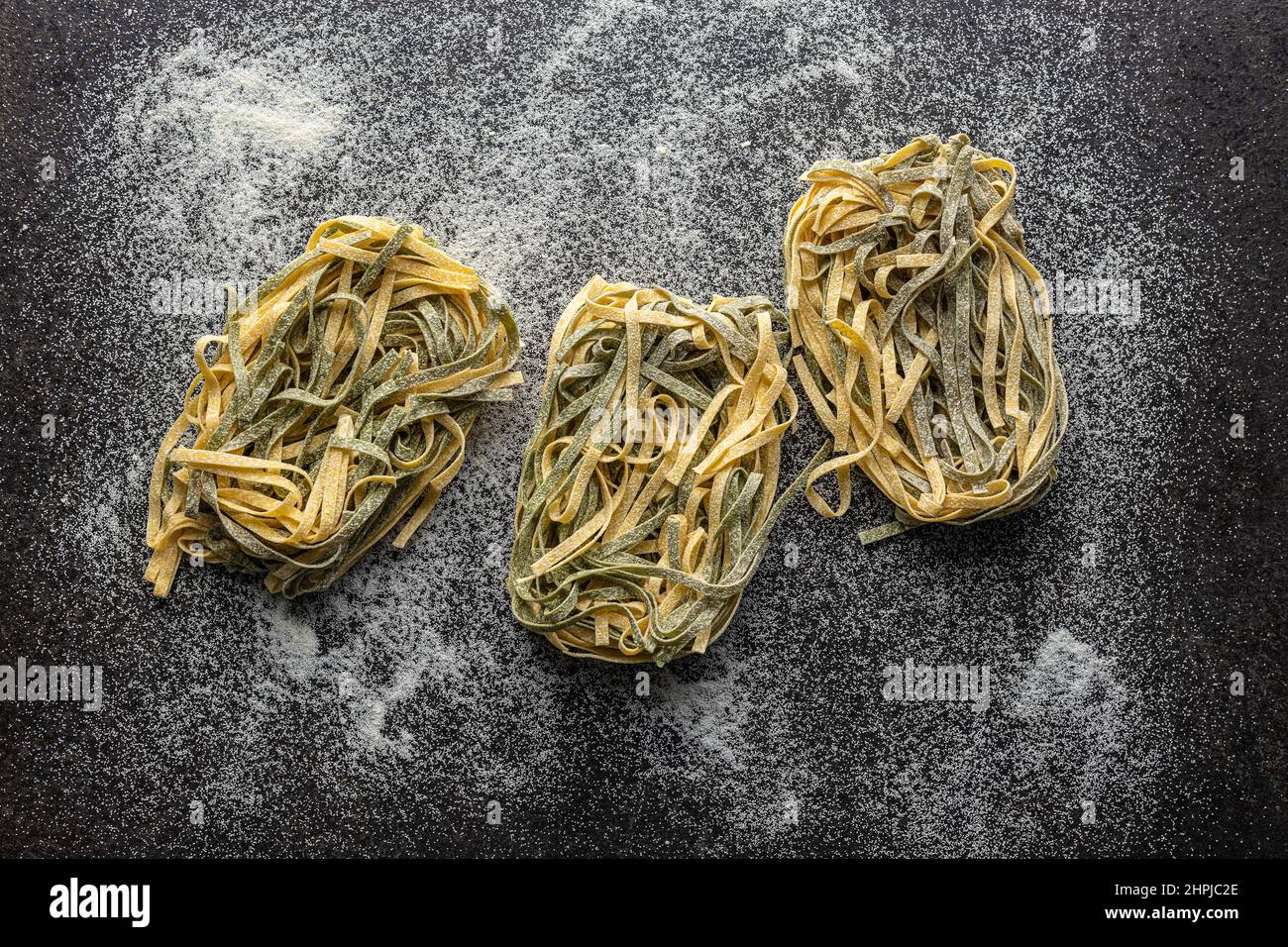 Egg pasta. Noodles nest with spinach flavor on a kitchen table. Top