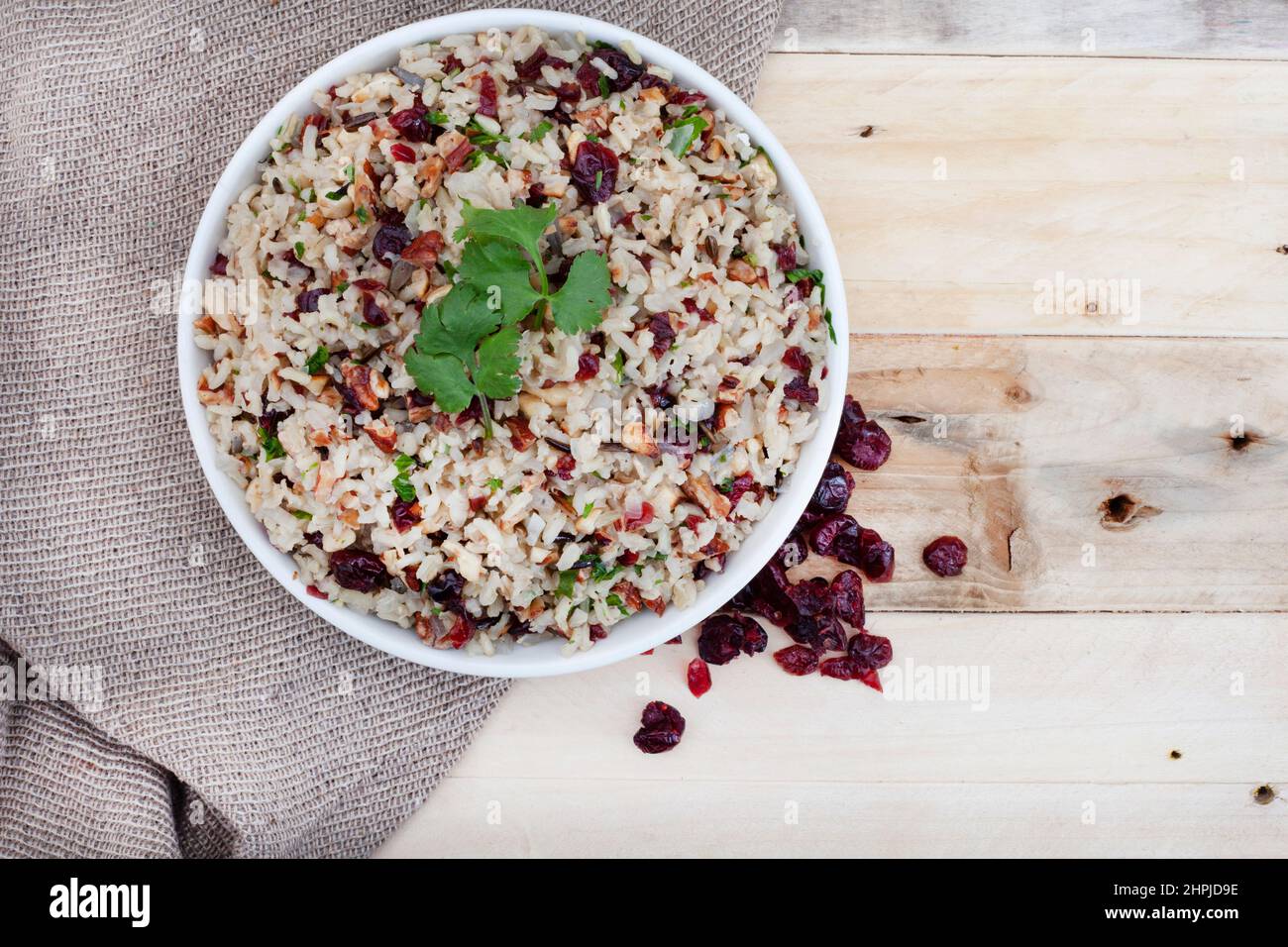 wild rice pilaf with cranberries and pecan nuts on rustic surface with