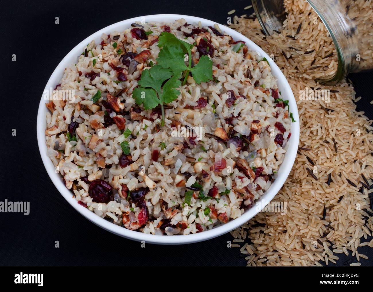 wild rice pilaf with cranberries and pecan nuts on rustic surface with