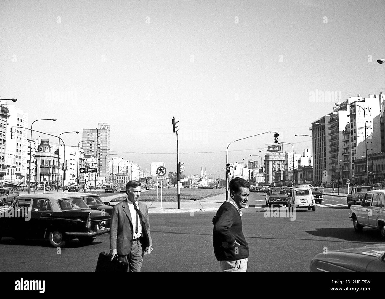 ARG 264B Buenos Aires Argentina 1973 9th July Avenue and city centre traffic scene with two businessmen inforeground Stock Photo