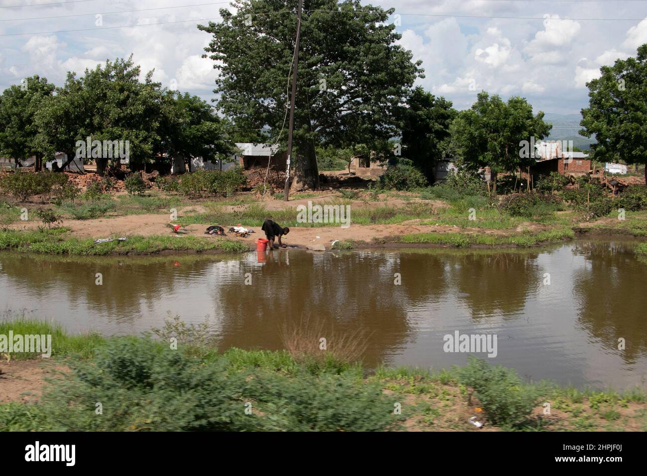 A young girl is seen using unclean flood water in Chikwawa district in Malawi. The district was hit by Tropical Cyclone Ana and some areas are still under water as it has not dried up. Malawi. Stock Photo