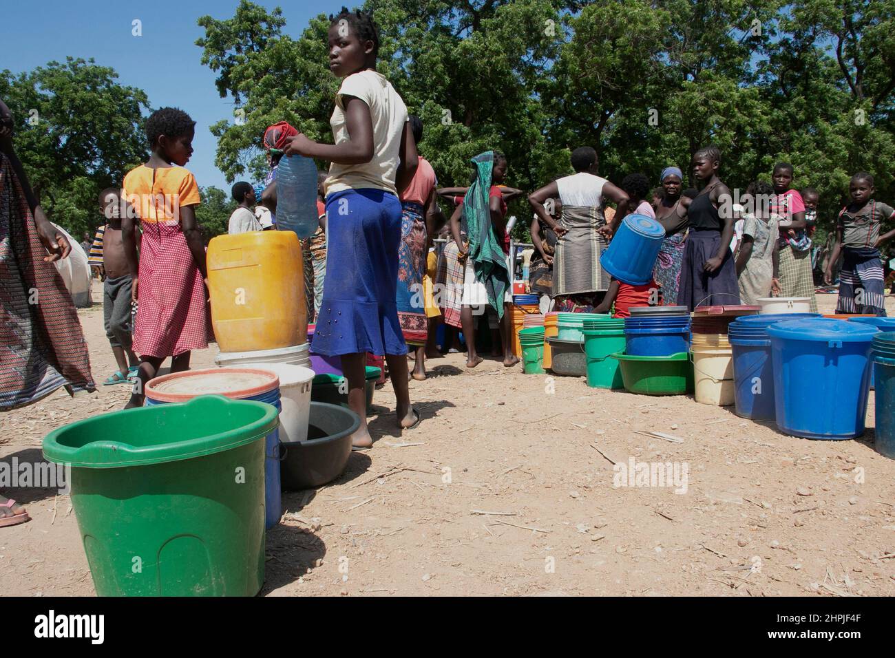 Women and children queue to fetch water at a water pumping station at Bangula Camp in Nsanje district, Malawi. Thousands of people are being housd at the camp after they were displaced by Tropical Cyclone Ana. Malawi. Stock Photo