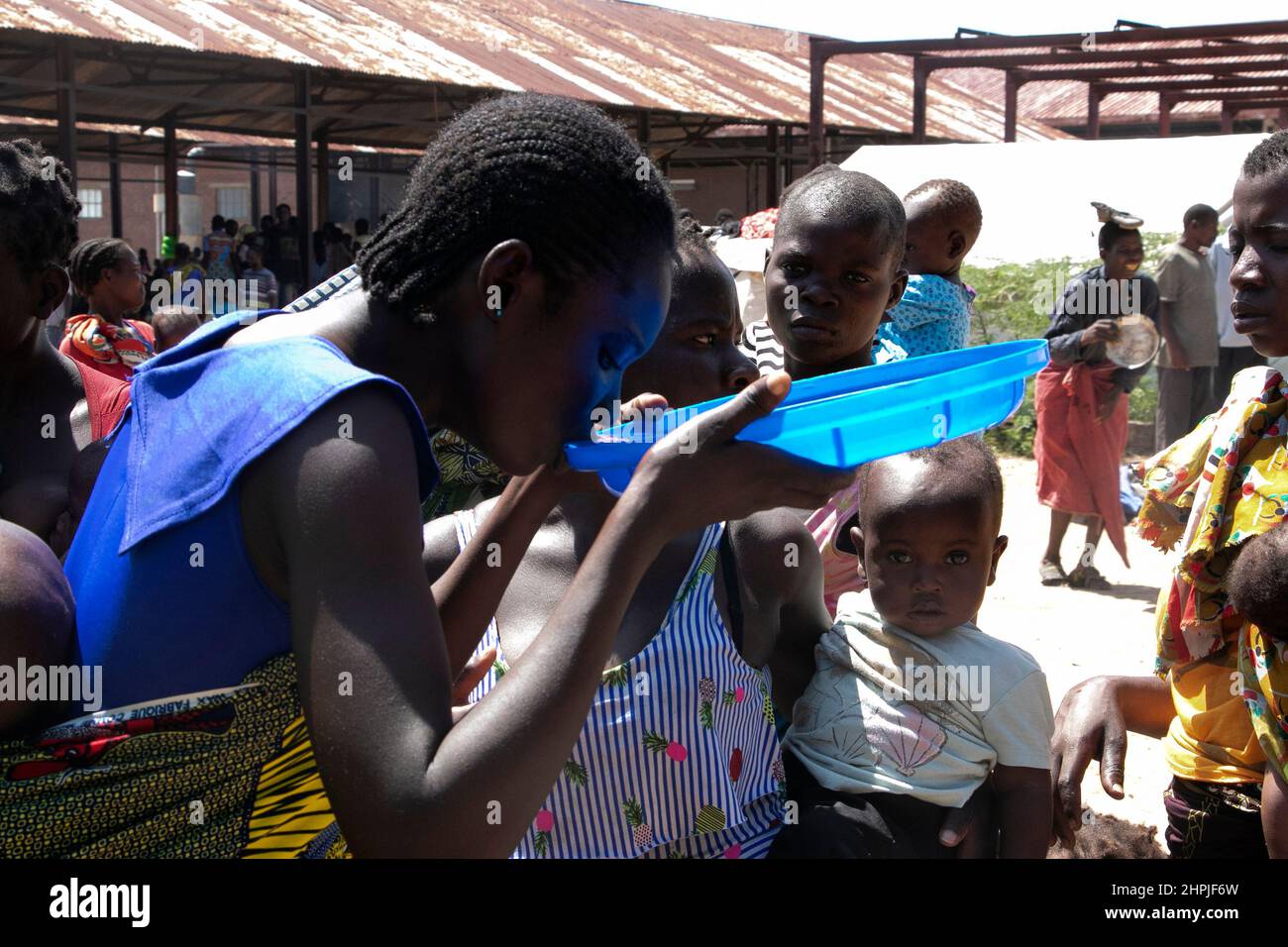 A woman is seen drinking water from the lid of a water bucket at Bangula Camp in Nsanje district, Malawi. Thousands of people are living in the camp after their homes were destroyed by Tropical Cyclone Ana. Malawi. Stock Photo