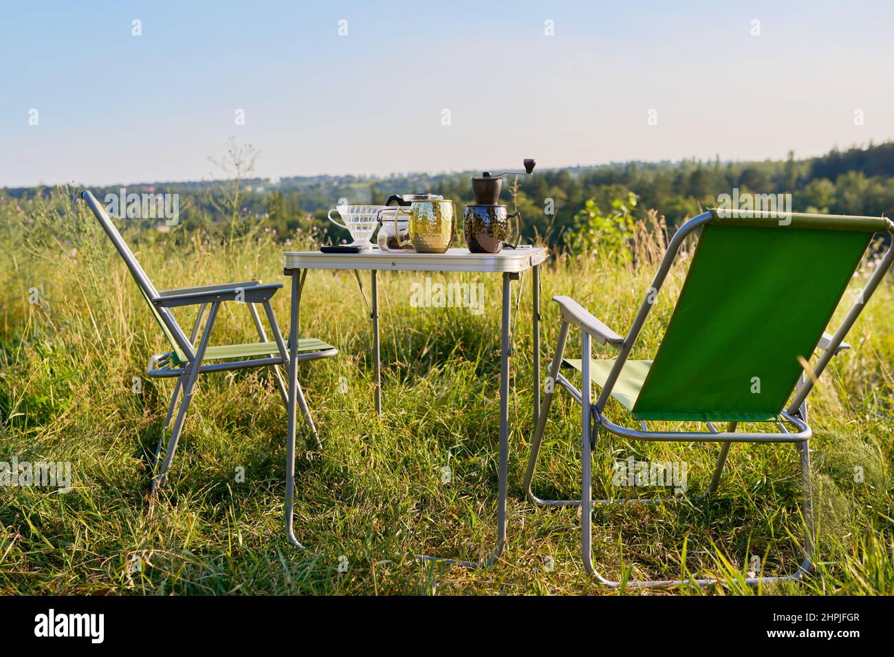 Set of folding furniture for camping, table and chair, summer nature of wild meadow Stock Photo