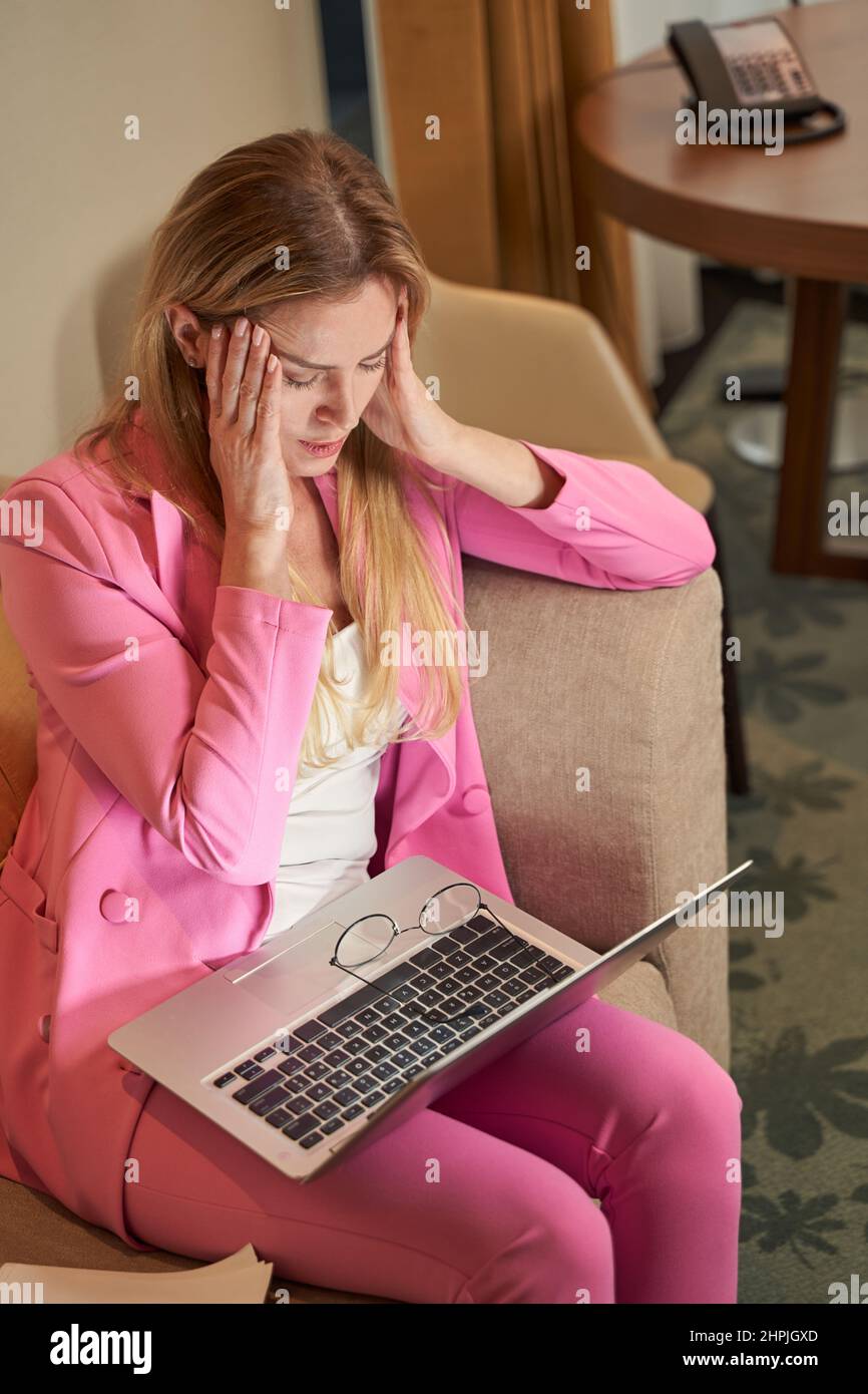 Tired lady having a headache after exhausting day at work Stock Photo
