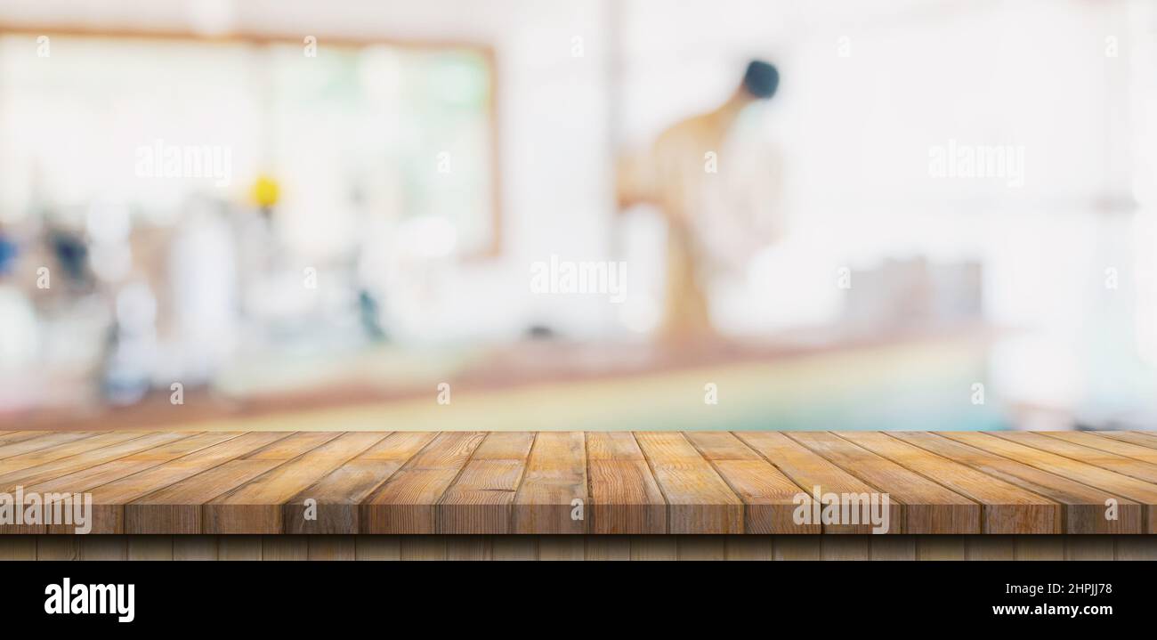 Wooden table top with blurred people in coffee shop and cafe background for display montage, copy space. Stock Photo