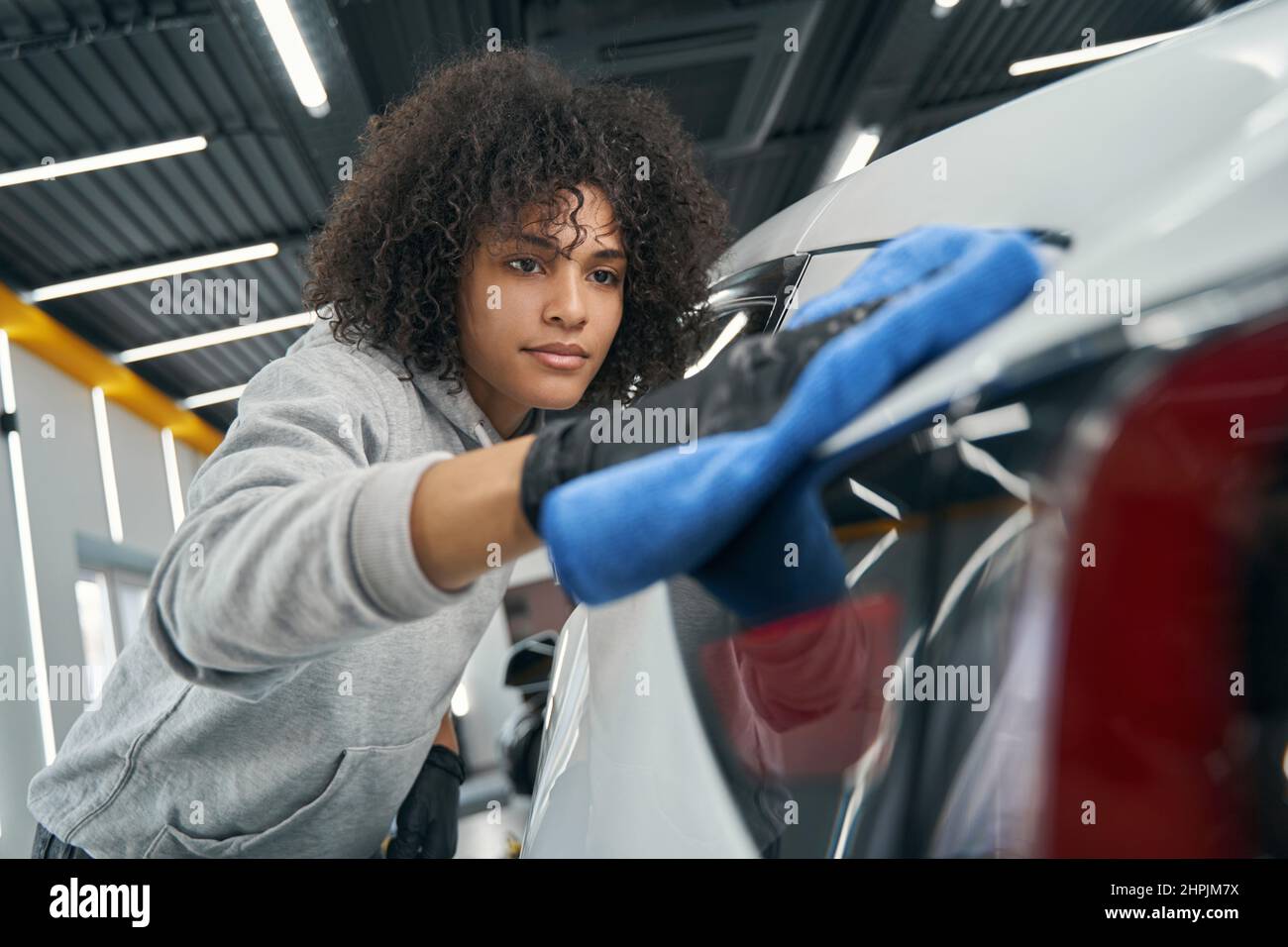 Auto detailer wiping outer body panel with soft cloth Stock Photo