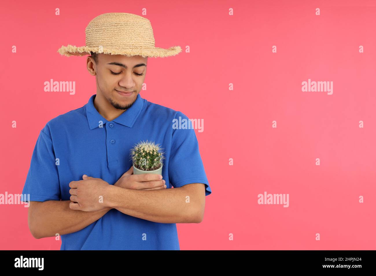 Young man with cactus on pink background Stock Photo