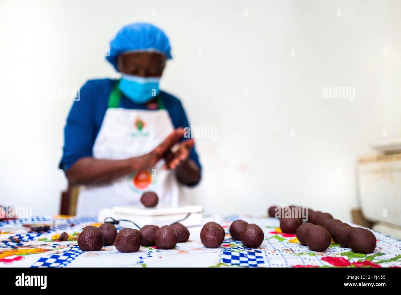 An Afro-Colombian farmer, rolls the raw cacao paste with hands into balls in a chocolate manufacture in Cuernavaca, Cauca, Colombia. Stock Photo