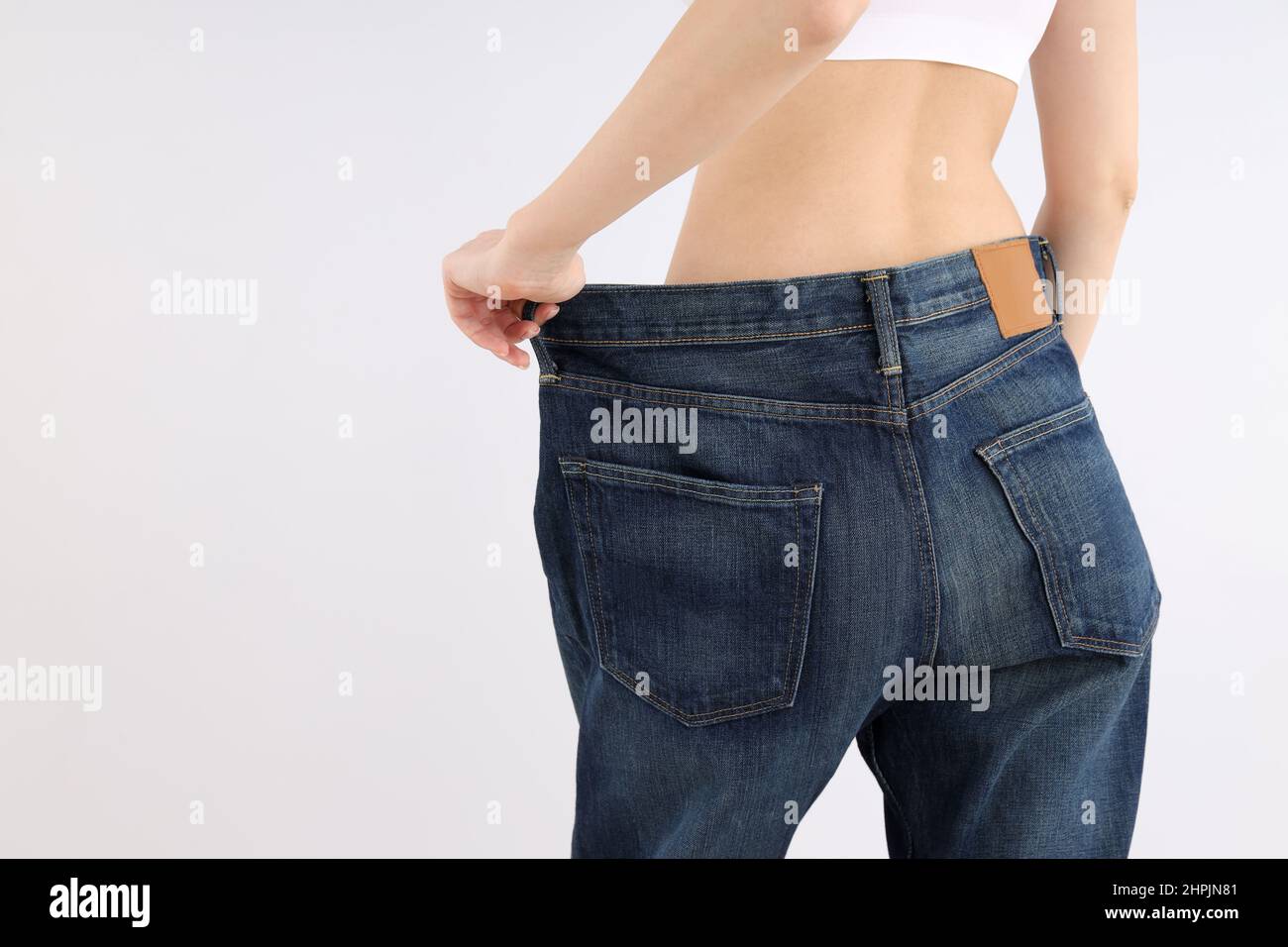 Concept of weight loss with young slim woman on light background Stock Photo