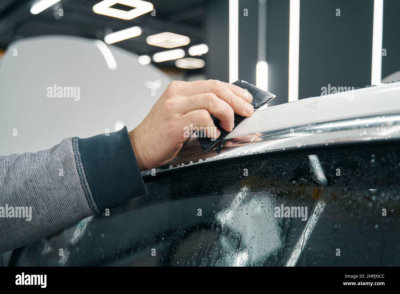 Auto detailer using squeegee for plastic car wrapping Stock Photo Alamy