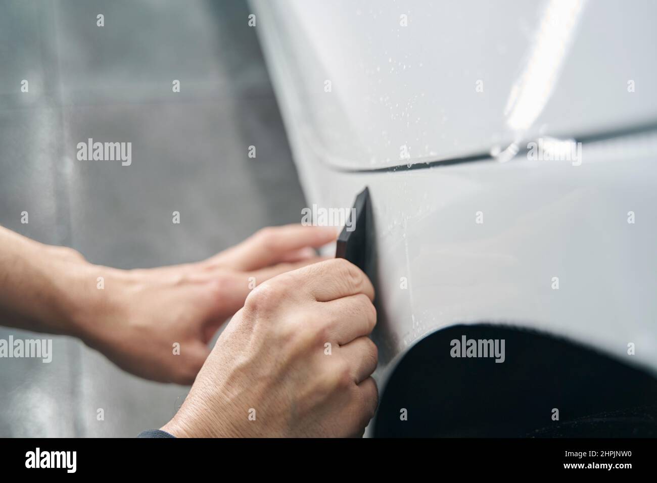 Worker hands polishing exterior surface of auto body panel Stock Photo