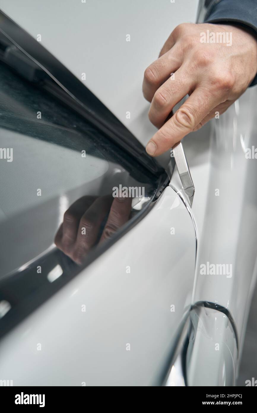 Detailer using utility knife for cutting PPF coating Stock Photo