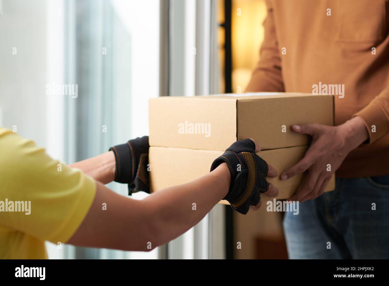 Closeup of man getting the parcel in box from delivery person Stock