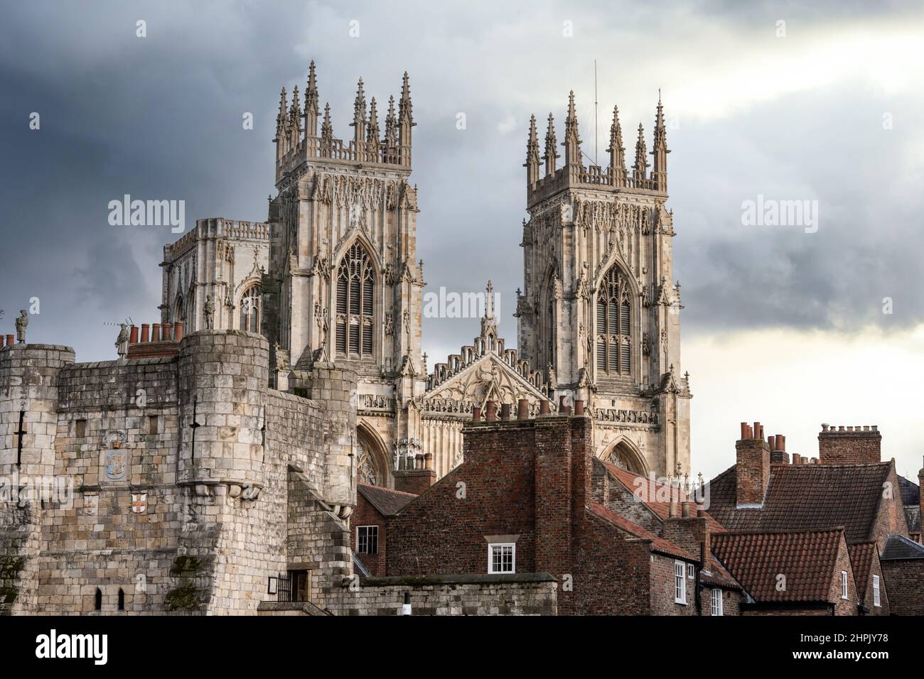 York minster church towers and windows above city streets and rooftops with stormy clouds and dramatic sky. Stock Photo