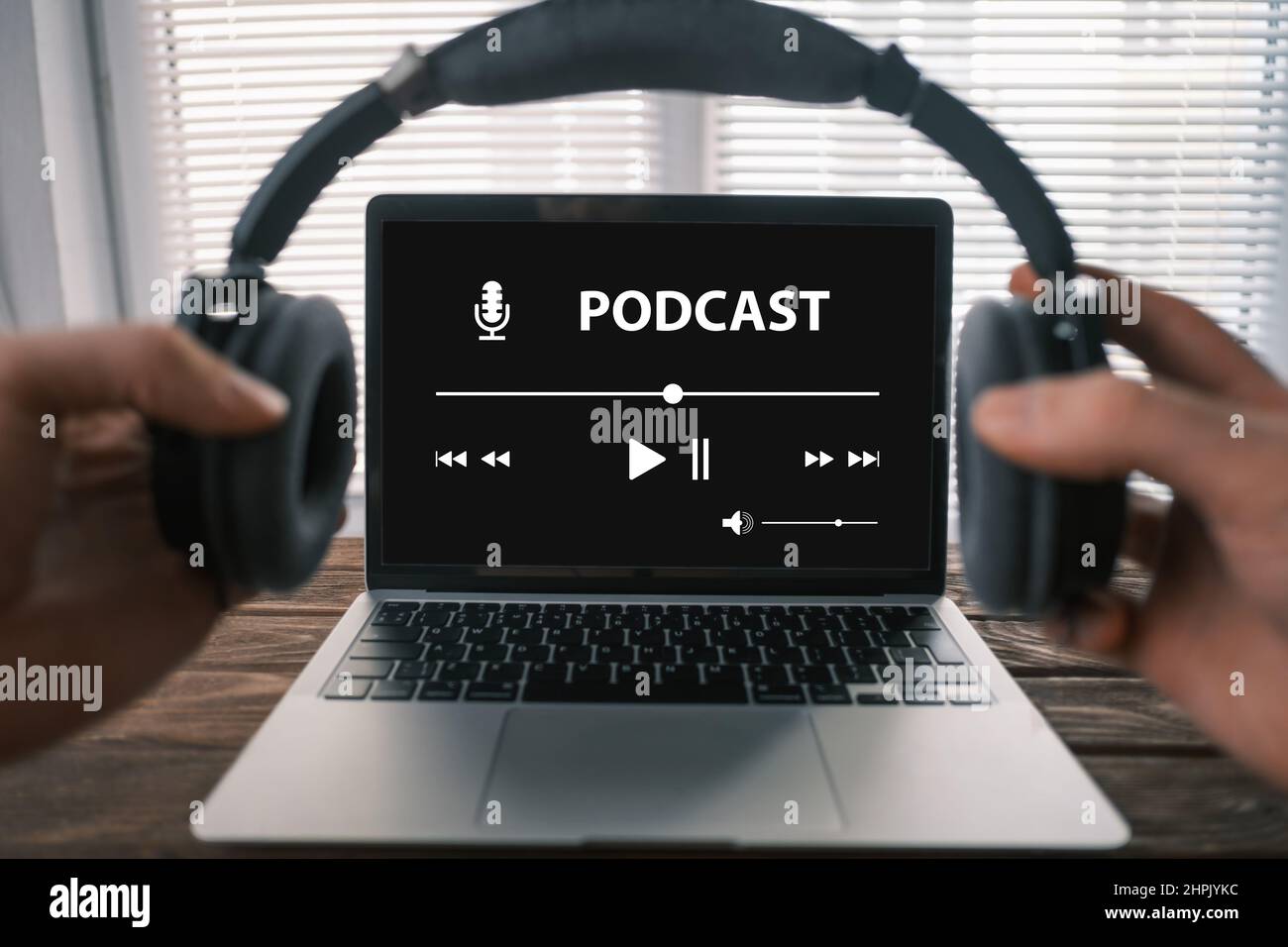 Point of view. A man puts on headphones to listen to an online podcast