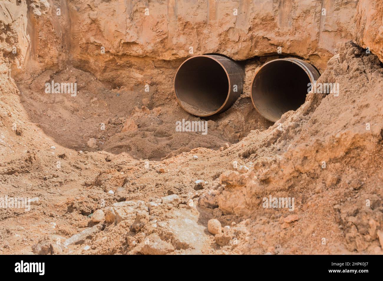 Repair of the pipeline line steel round pipe the heating main in the ground construction work industrial. Stock Photo